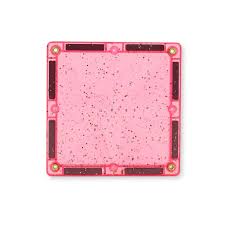 Vista de perto de uma telha magnética quadrada cor-de-rosa com glitter, mostrando a textura e os ímanes.