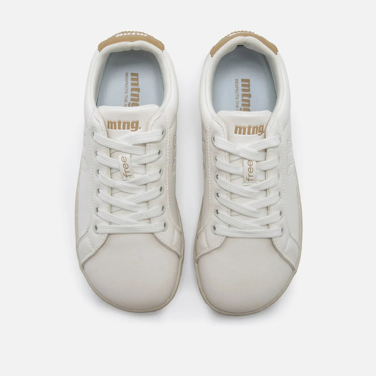 Vista superior de um par de ténis brancos Mustang (MTNG) Free Aria, mostrando os atacadores brancos e o interior com a inscrição 'mtng free'.
