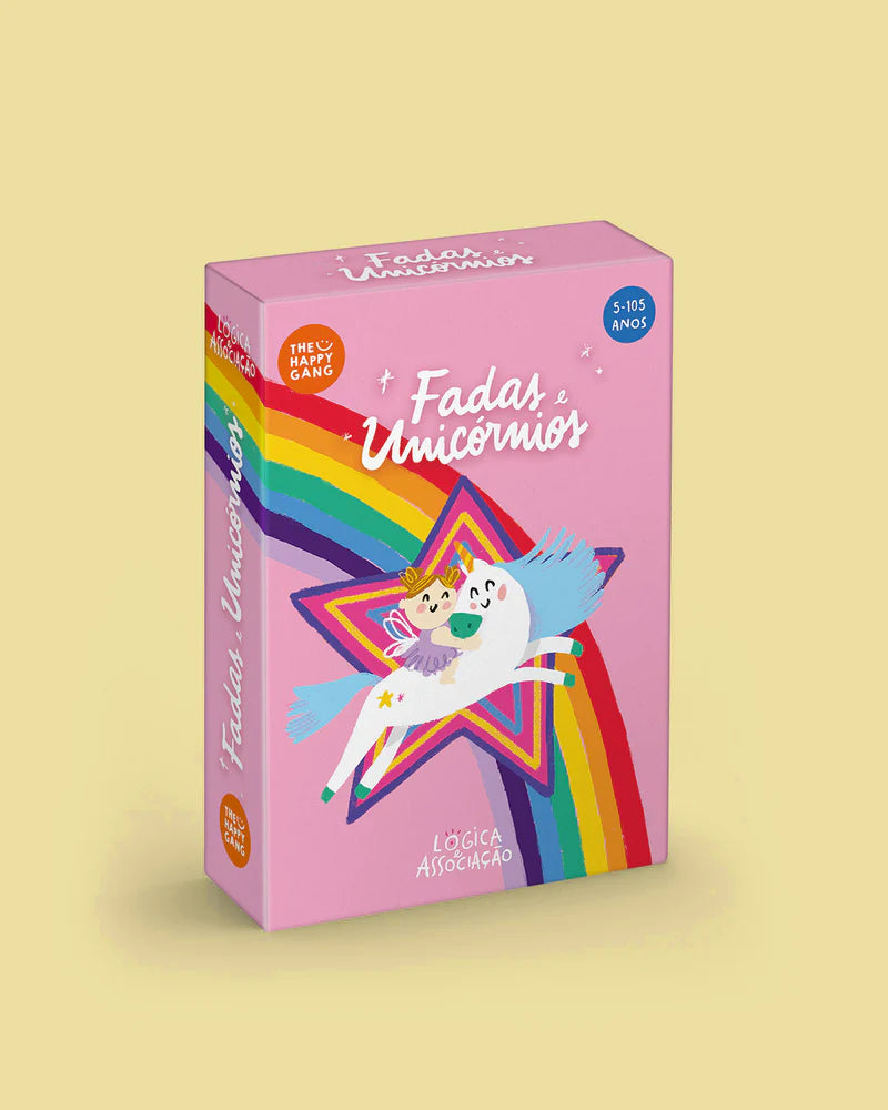 Caixa do jogo de cartas "Fadas e Unicórnios" da The Happy Gang, cor-de-rosa, com arco-íris e um unicórnio a saltar. Indica idade 5-105 anos.