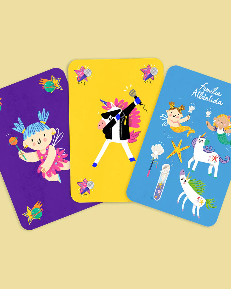 Três cartas do jogo de associação "Fadas e Unicórnios": uma fada, um unicórnio estrela pop e a família Atlântida com sereias e unicórnios.