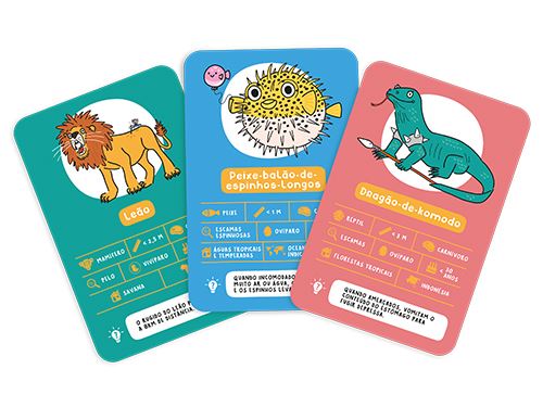 Três cartas de jogo em destaque: Leão, Peixe-balão-de-espinhos-Longos e Dragão-de-Komodo, mostrando o design informativo e ilustrativo.