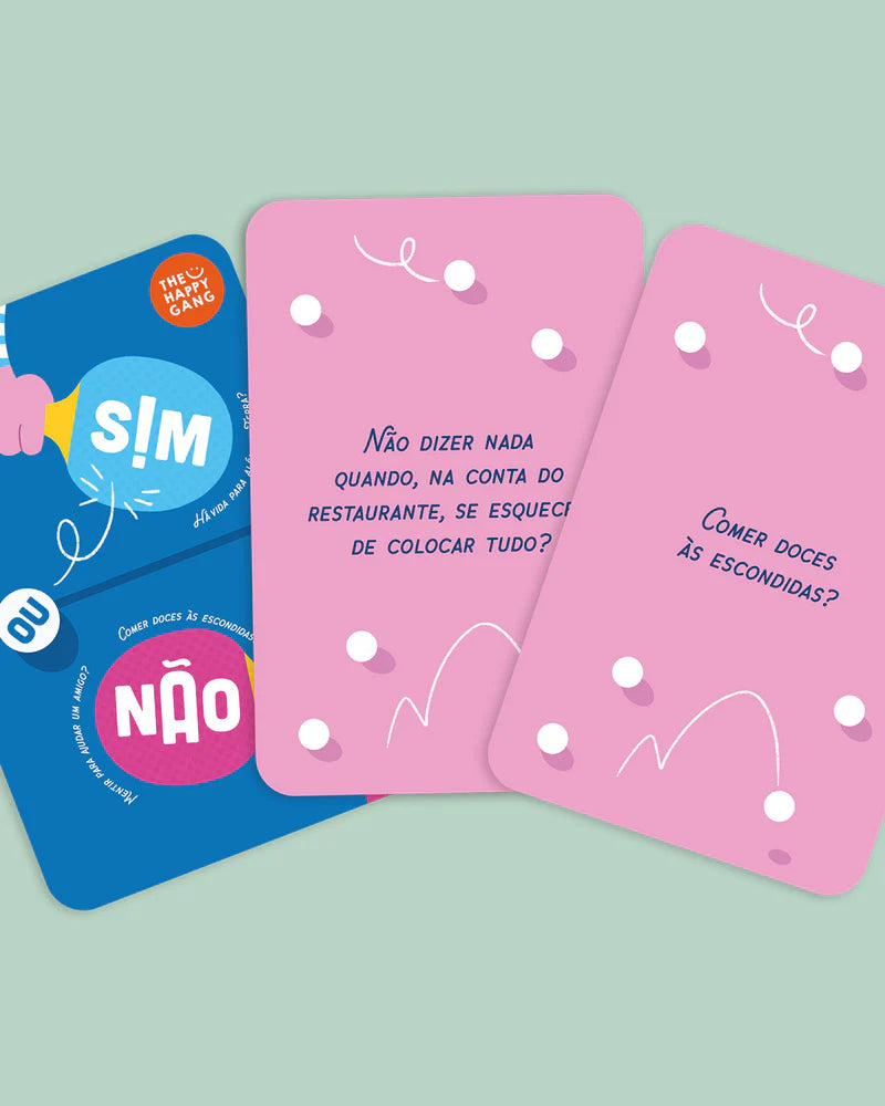 Três cartas do jogo "Sim ou Não" em destaque: a capa azul e duas cartas cor-de-rosa com perguntas de dilemas.