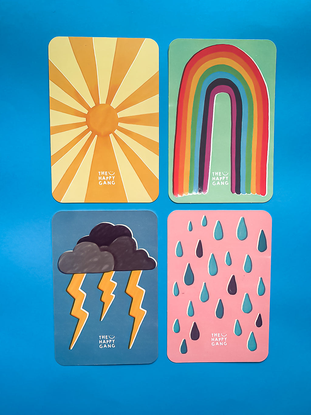 Imagem de uma criança (5+) a interagir com as cartas do baralho "THE HAPPY GANG" num momento de partilha familiar.