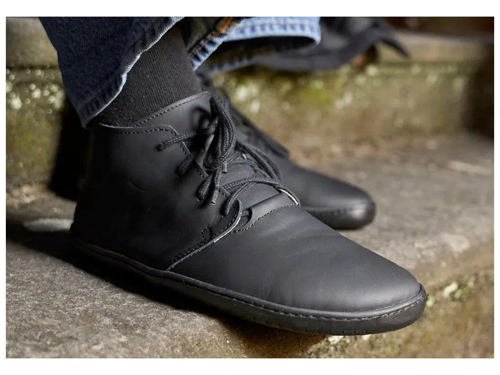 Perfil das botas barefoot TIKSI femininas em preto, um modelo discreto e sofisticado.

