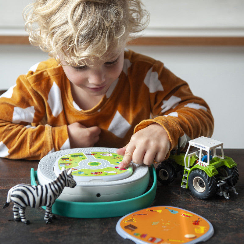 Outra criança a usar o Timio Conjunto 4, mostrando a facilidade de uso e a interação com o brinquedo.