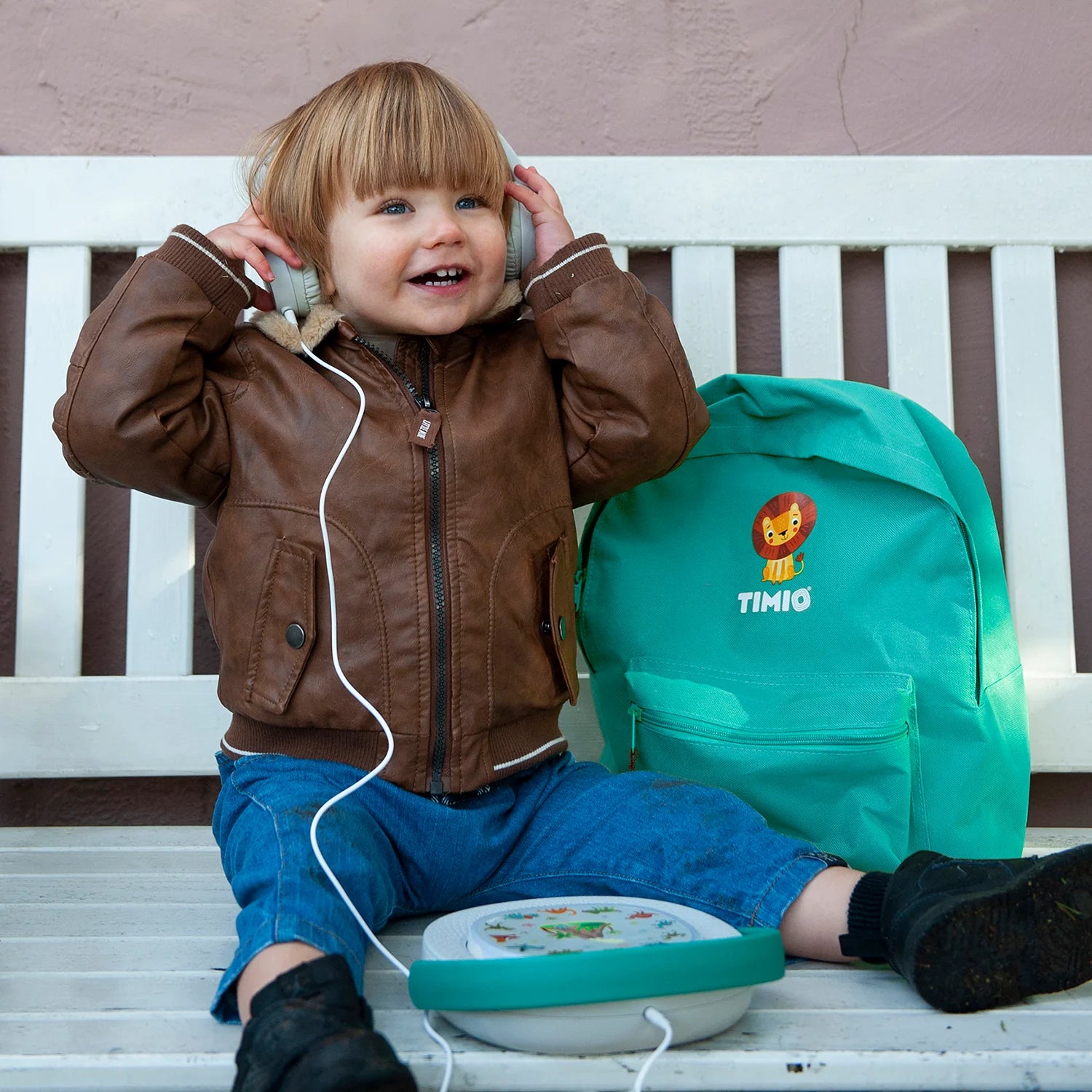 Detalhe lateral dos auscultadores Timio, mostrando o mecanismo de ajuste de tamanho e o logótipo "Timio" na concha.