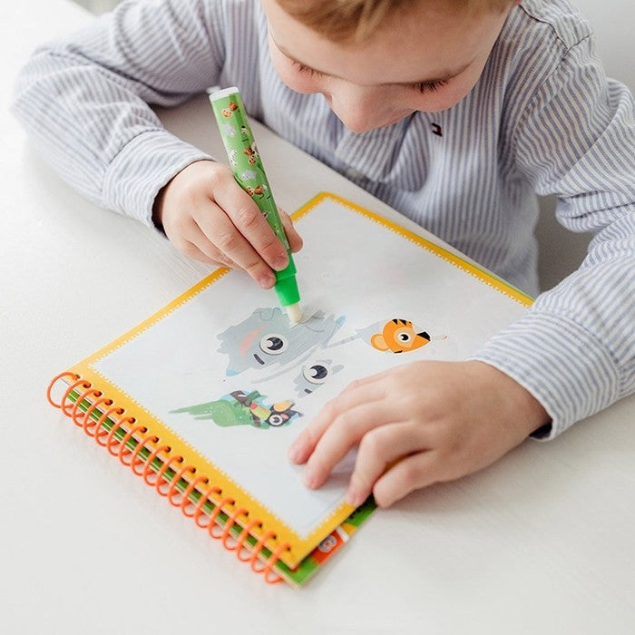 Criança a usar a caneta mágica no Livro de Colorir Totum Aquamagic tema Vida Selvagem.