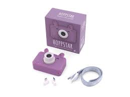 Conjunto da máquina fotográfica digital Hoppstar Rookie Blossom roxa, caixa, cordão e adaptadores, dispostos sobre fundo branco.