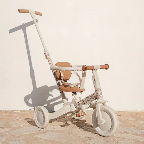 Triciclo 4 em 1 Little Dutch em cor creme e castanho com estampa floral, em modo de passeio com barra de empurrar parental.