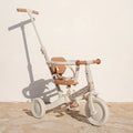Triciclo 4 em 1 Little Dutch em cor creme e castanho com estampa floral, em modo de passeio com barra de empurrar parental.