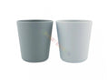 Pack de 2 copos infantis Trixie cor petróleo, um cinzento escuro e outro azul claro, fabricados em PLA vegetal.
