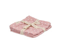 Conjunto de 2 musselinas Lassig cor rosa claro com padrão de pequenas folhas brancas, dobradas e atadas com uma fita com a marca "tutete".