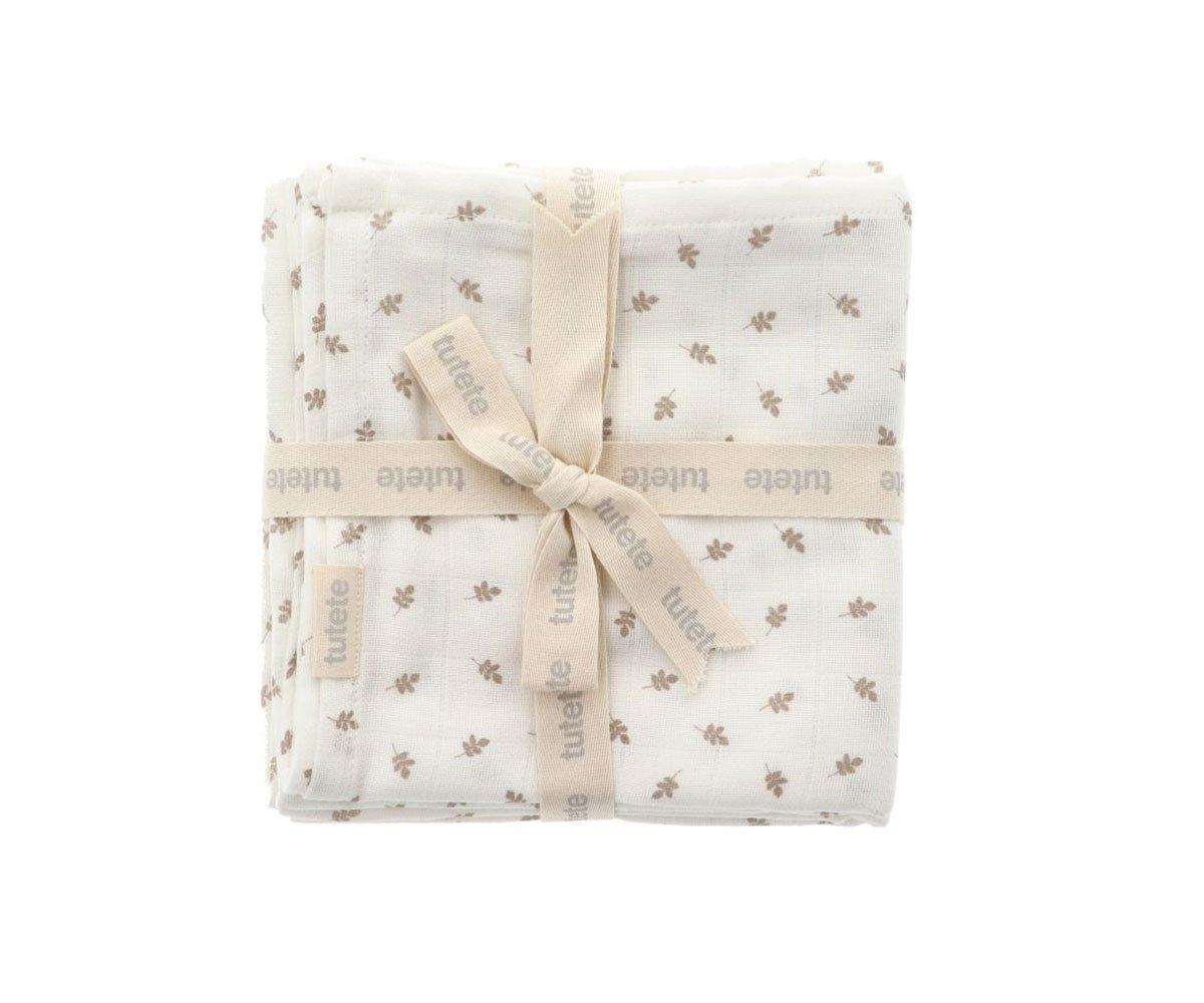 Vista frontal detalhada do conjunto de 2 musselinas brancas com padrão de folhas castanhas, firmemente atadas com fita de marca, destacando a textura suave do tecido.