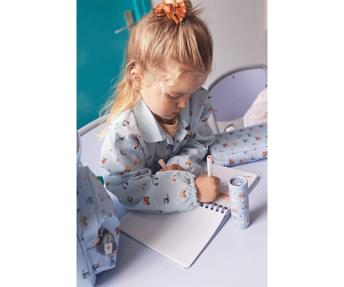 Criança loira a usar um estojo Tutete azul estampado enquanto escreve num caderno, ilustrando o uso prático do produto.