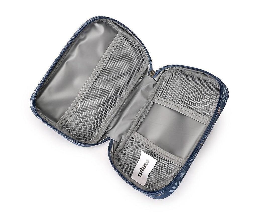 Interior da bolsa de medicamentos Tutete aberta, revelando forro impermeável e três bolsos de rede para organização de itens. Etiqueta "tutete" visível.