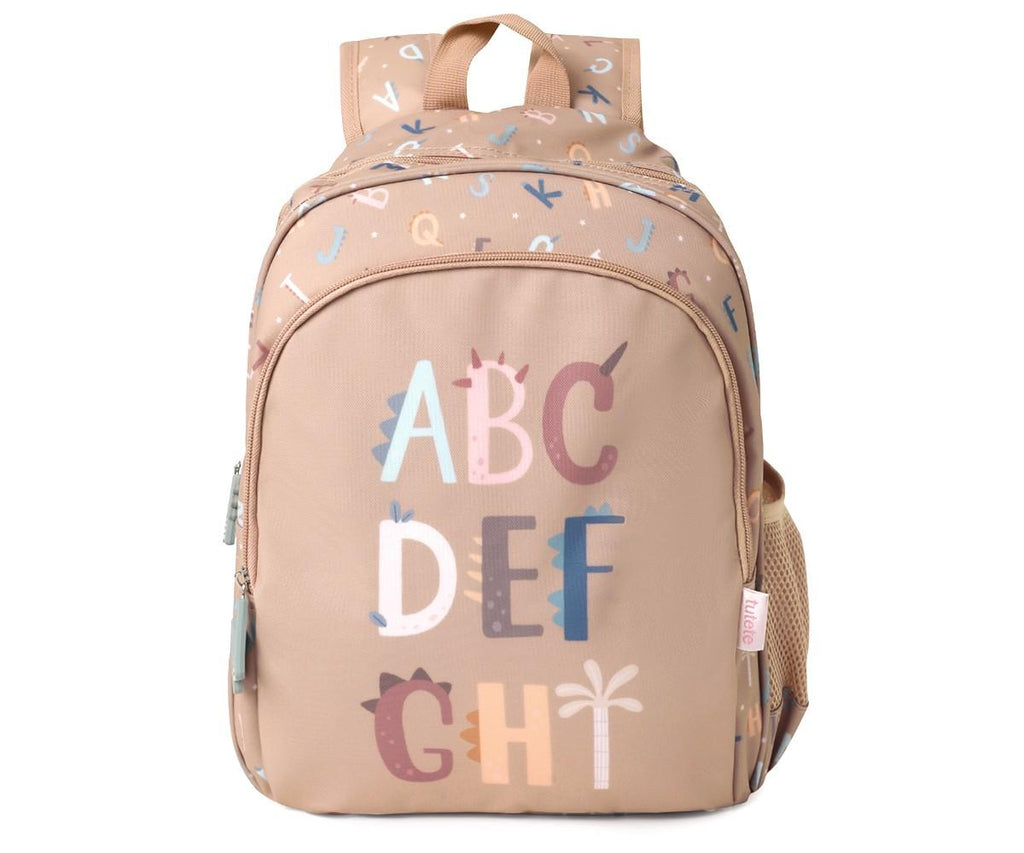 Mochila escolar Tutete bege com padrão de letras e dinossauros, exibindo "ABC DEF GHI" na frente.