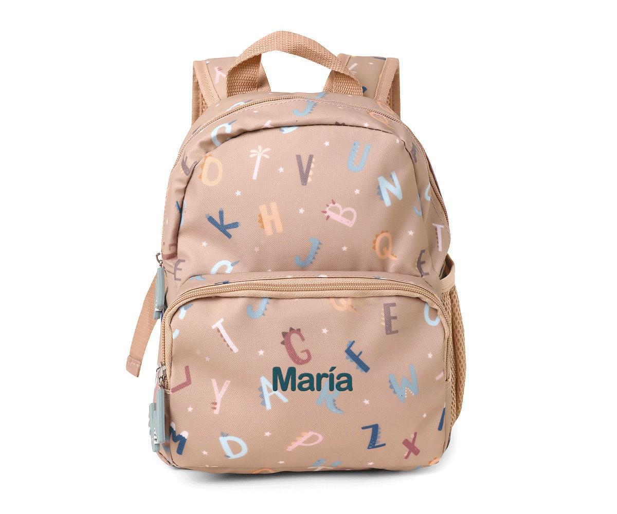Vista frontal da mochila infantil Tutete bege com padrão de letras coloridas e personalização com o nome "María", mostrando o bolso lateral em malha.