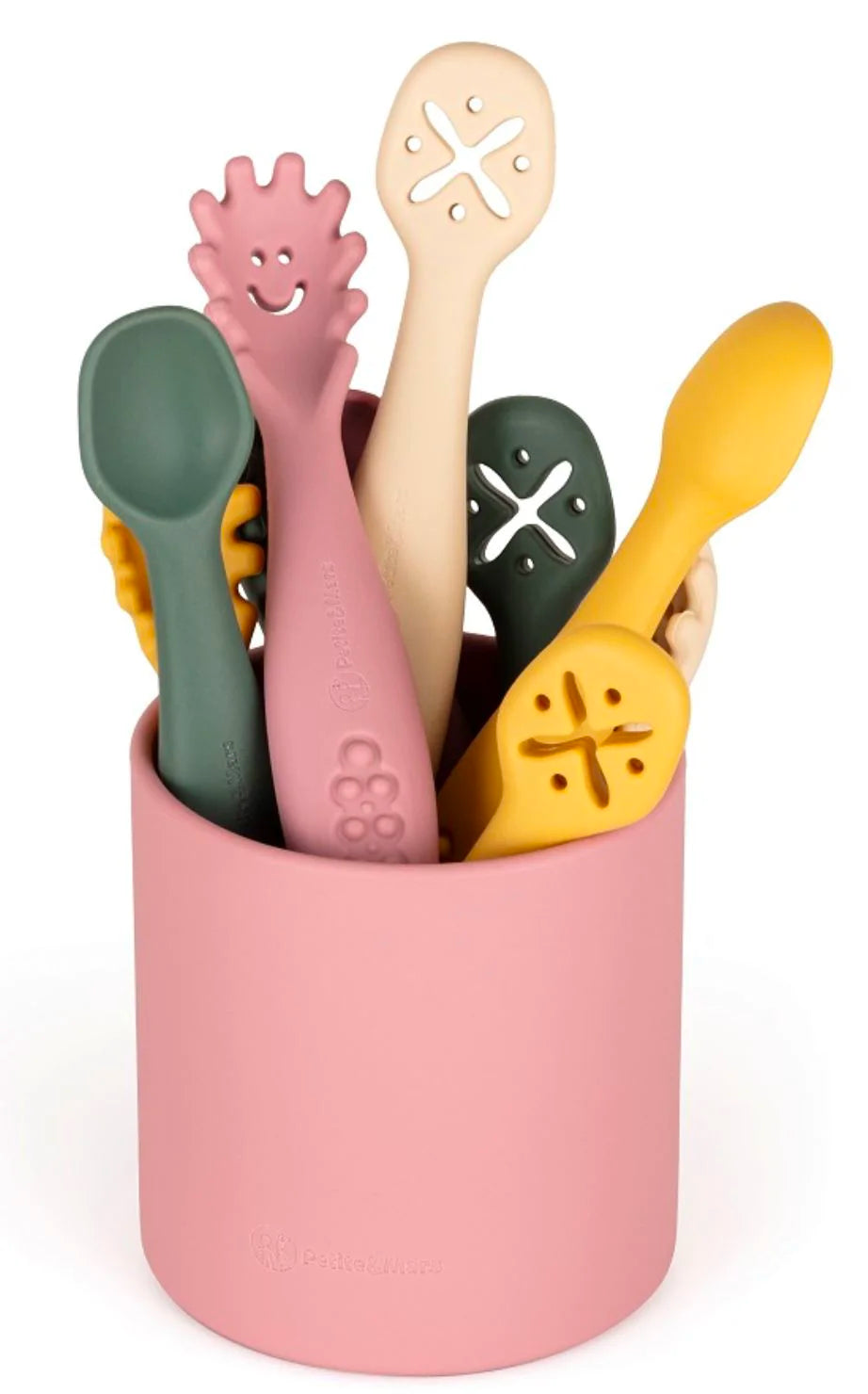 Várias colheres de silicone de diferentes cores (rosa, verde, amarelo, bege) encaixadas num recipiente cilíndrico rosa, com algumas colheres visíveis por fora.