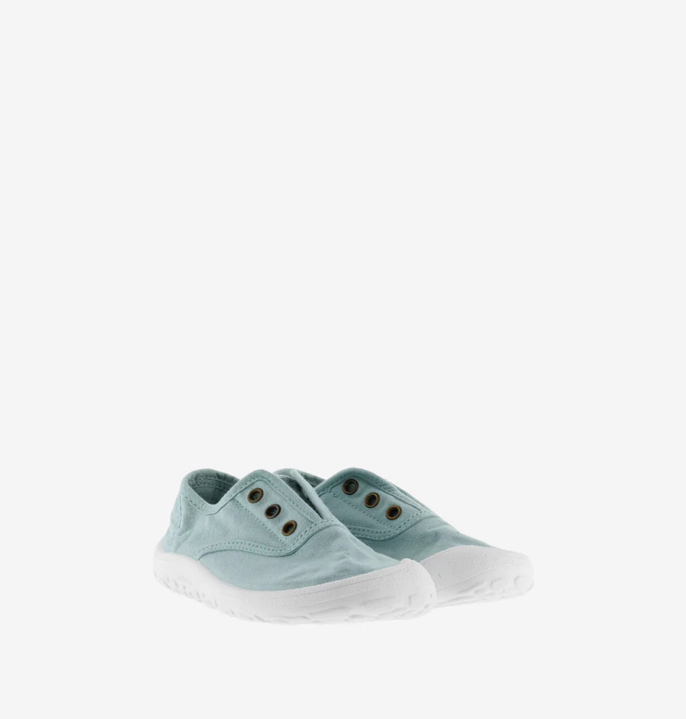 Par de sapatilhas Victoria Barefoot estilo Manzana em lona azul-claro, tipo slip-on com ilhós para elásticos, sola branca flexível.