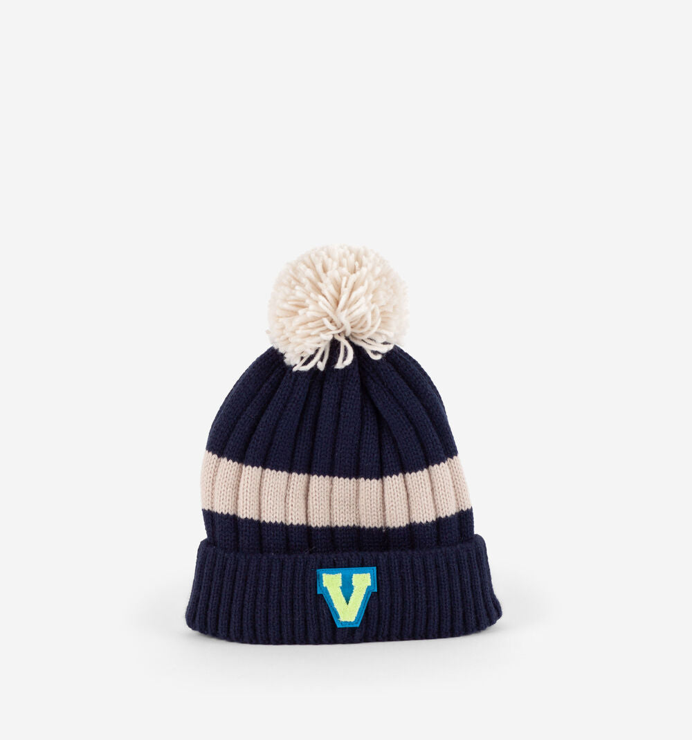 Gorro Victoria para criança em azul marinho com listras bege, pompom e aplique da marca "V" no rebordo.