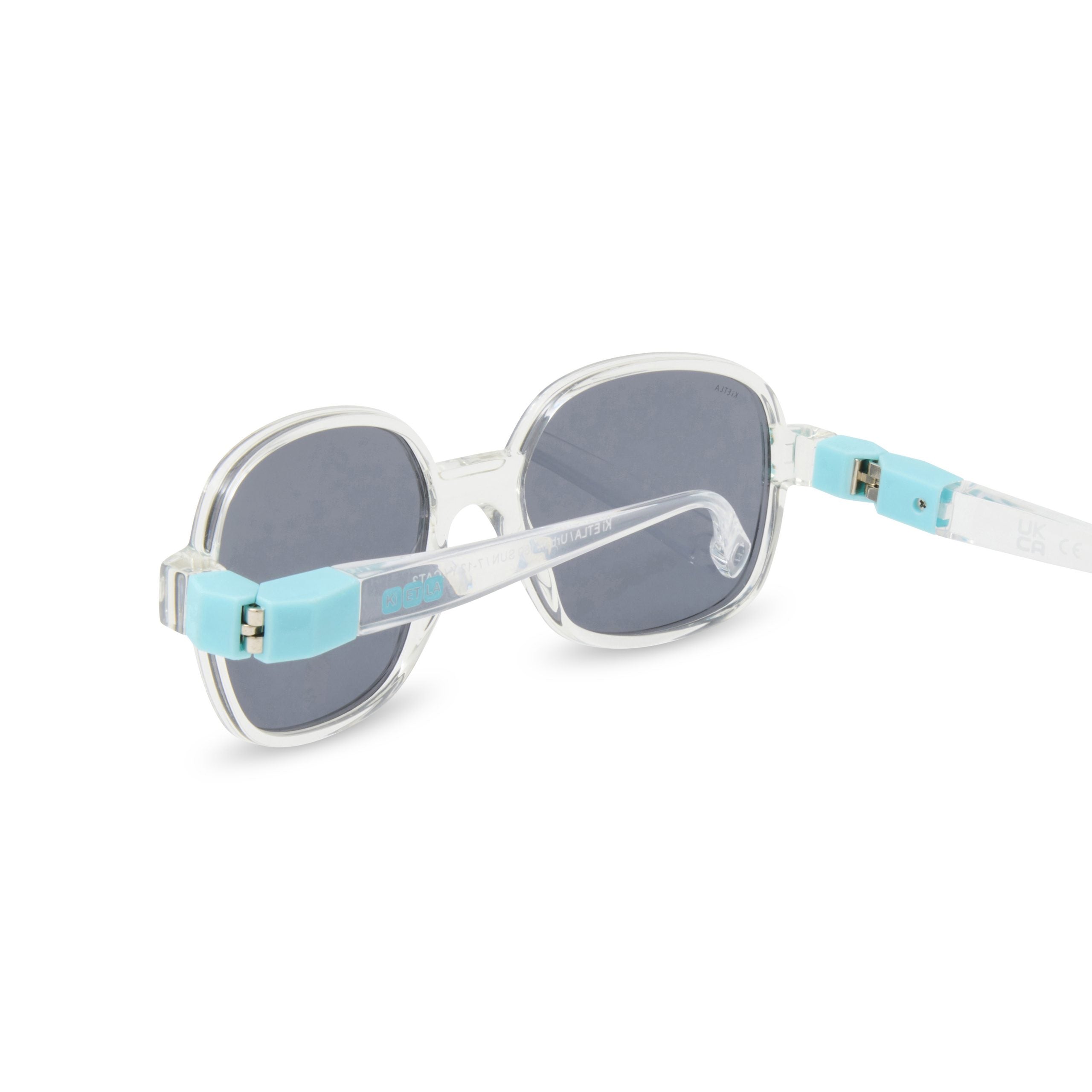 Vista traseira dos óculos de sol Kietla Urban, focando a articulação da haste flexível e as marcações CE e UK CA no interior da haste.