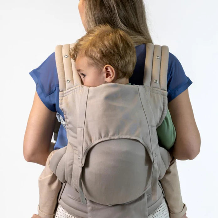 Vista traseira de uma mulher a usar a mochila Isara ELITE bege, transportando uma criança mais crescida nas costas, mostrando o ajuste das alças acolchoadas.