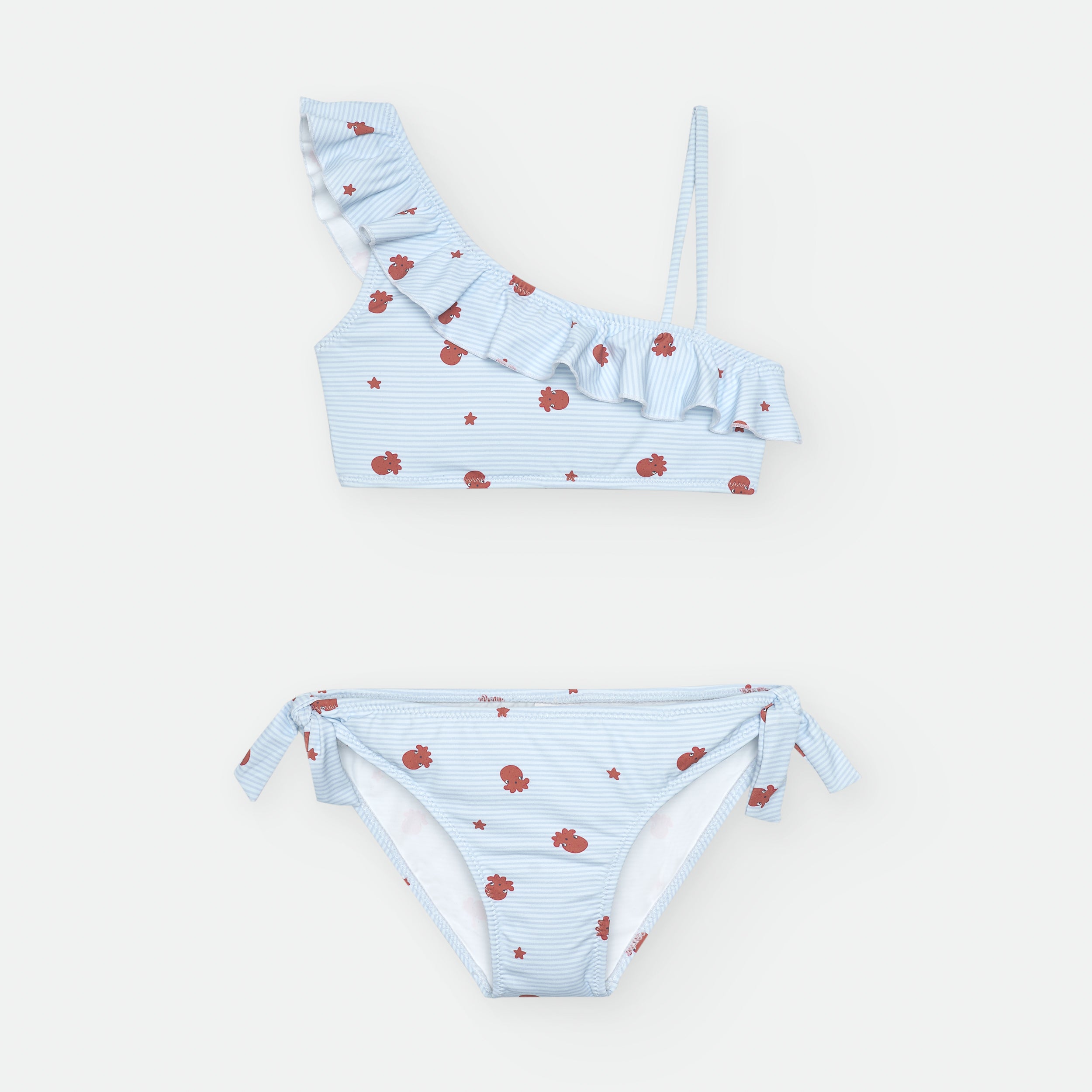 Biquini Waterlemon infantil azul claro, com top assimétrico com folho e cueca com laços. Estampado com polvos e estrelas. Vista frontal.