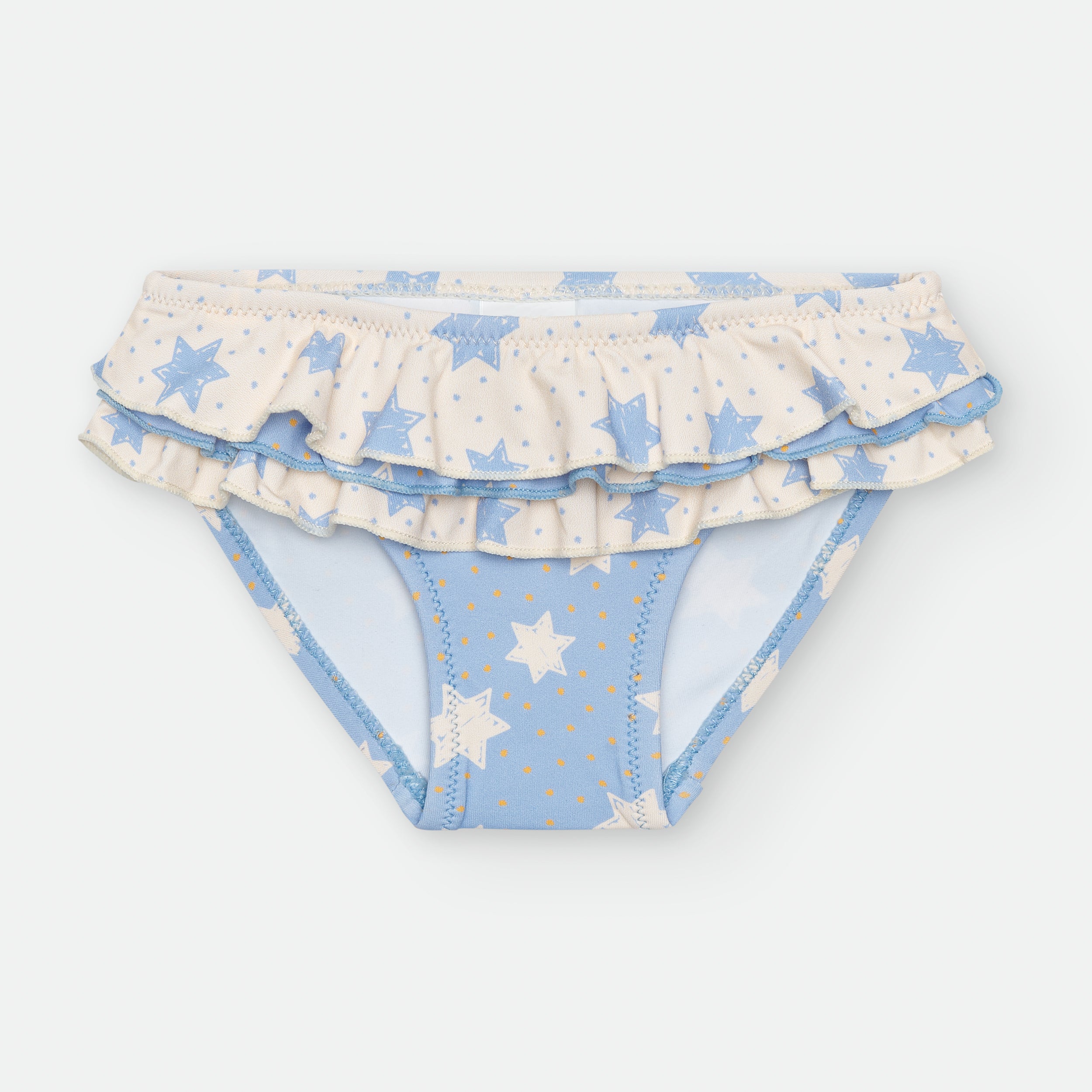 Vista frontal da cueca de praia Waterlemon para menina, padrão estrelas azuis e bege, com folhos duplos na cintura.