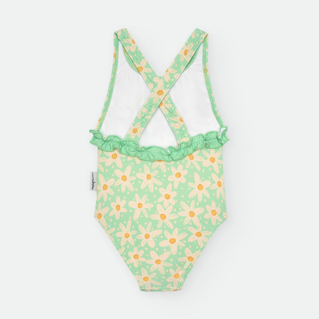 Vista traseira do fato de banho infantil verde com margaridas, destacando as alças cruzadas e o folho franzido na zona lombar.