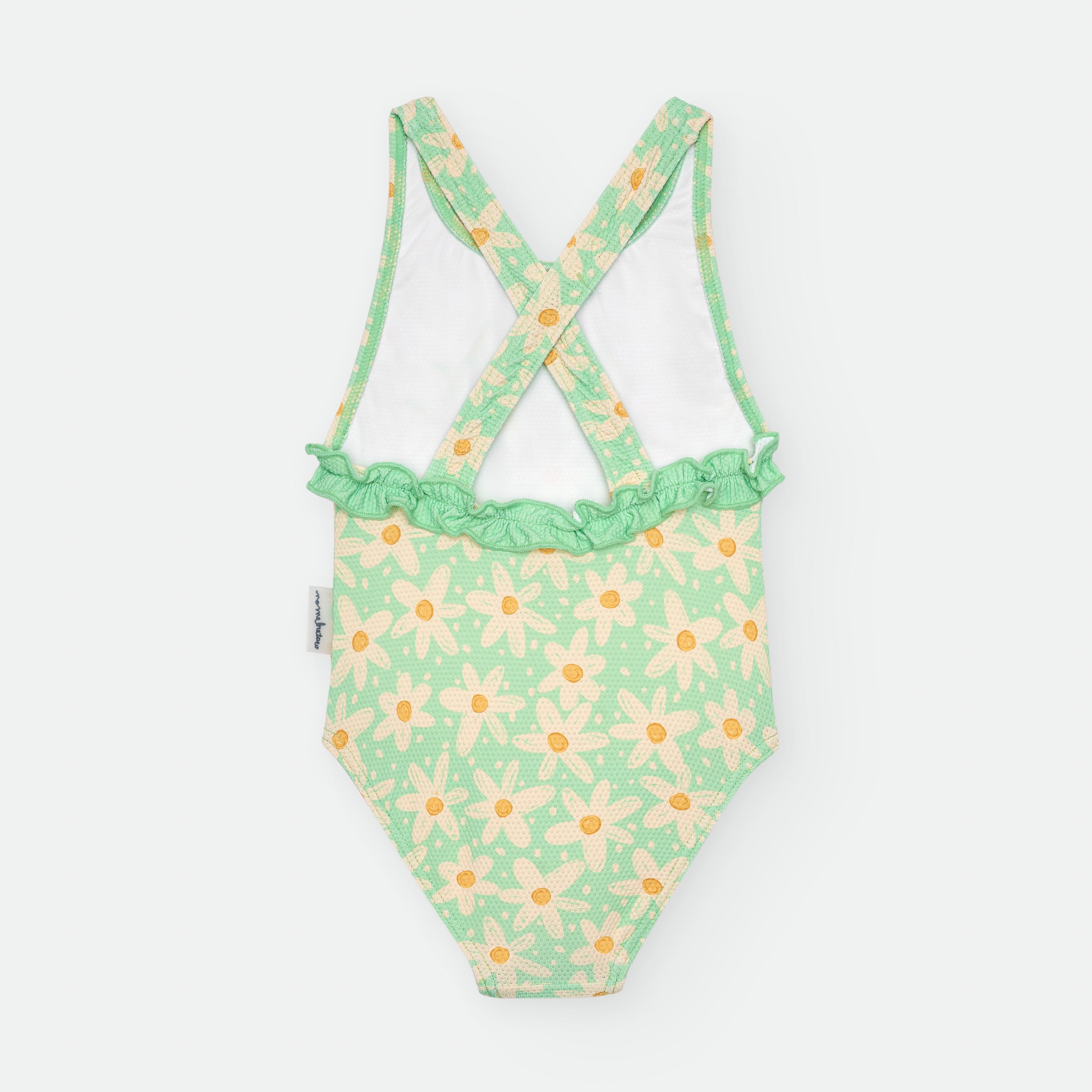 Vista traseira do fato de banho infantil verde com margaridas, destacando as alças cruzadas e o folho franzido na zona lombar.