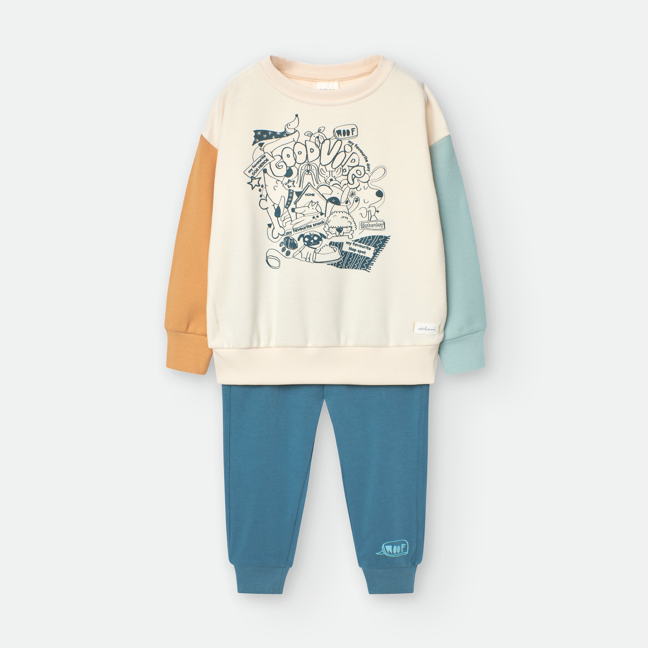 Fato de treino infantil Waterlemon de 2 peças: camisola creme com mangas color block (azul, bege/laranja) e estampado frontal, e calças azul-petróleo.