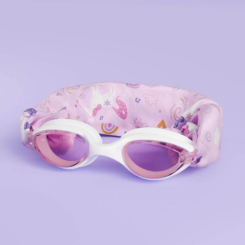Óculos de natação Waterplops brancos com lentes cor-de-rosa, apresentados sobre a sua banda elástica de unicórnios dobrada.