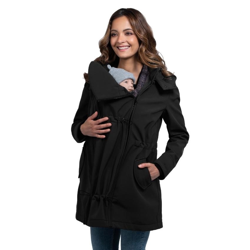 Close-up de mulher a usar o casaco Wombat Shell preto com um bebé pequeno (de gorro cinzento) transportado à frente.