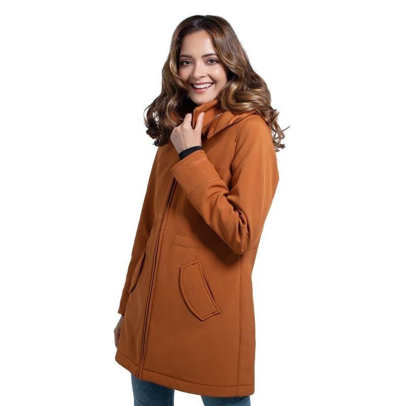Mulher sorri, vestindo o casaco Wombat Shell caramelo de manga comprida, em fundo branco, mostrando o estilo sem painel.