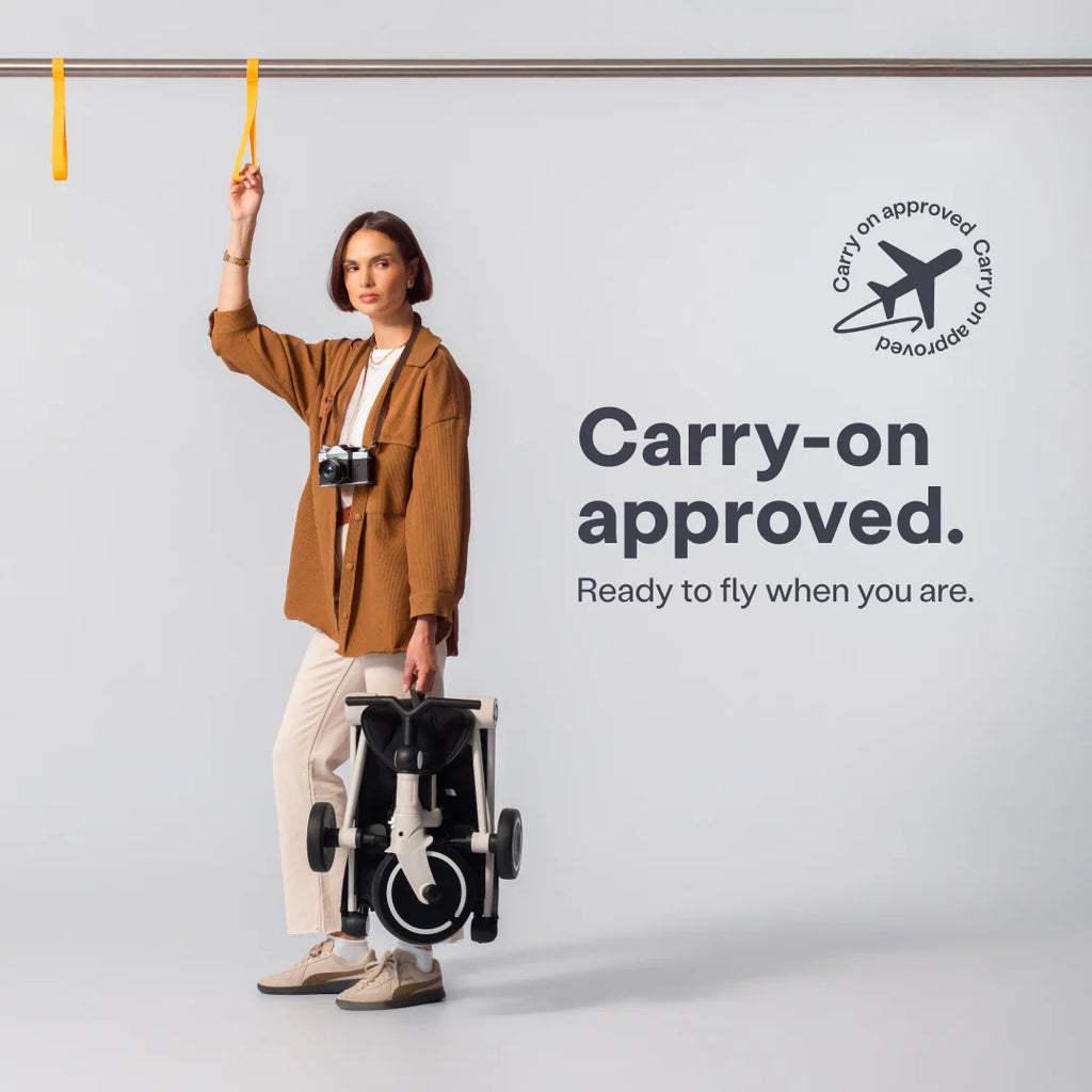 Uma mulher segura facilmente o SMARTRIKE Wonder dobrado, ilustrando a sua portabilidade e o selo de aprovação como bagagem de mão para aviões.