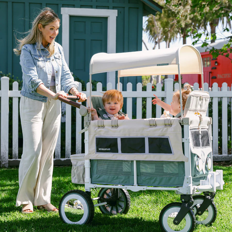 Crianças sentadas no Wonderfold Wagon W2, protegidas pela capota solar ajustável e com espaço para as pernas.