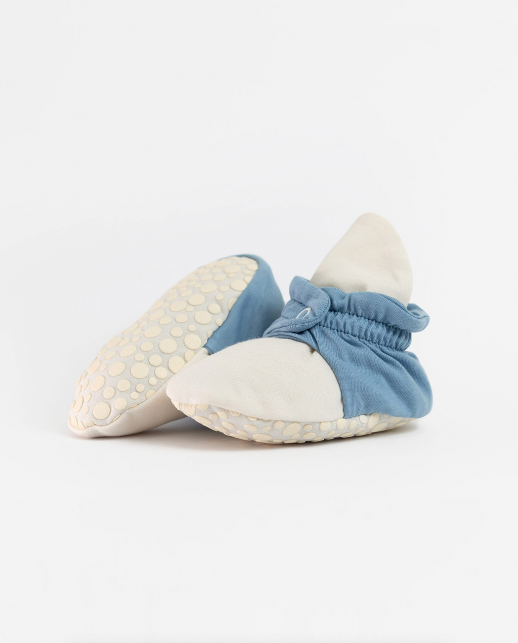 Par de pantufas botinhas de bebé Zás Trás 'Blue PopCorn' em algodão orgânico, mostrando a sola antiderrapante com bolinhas.