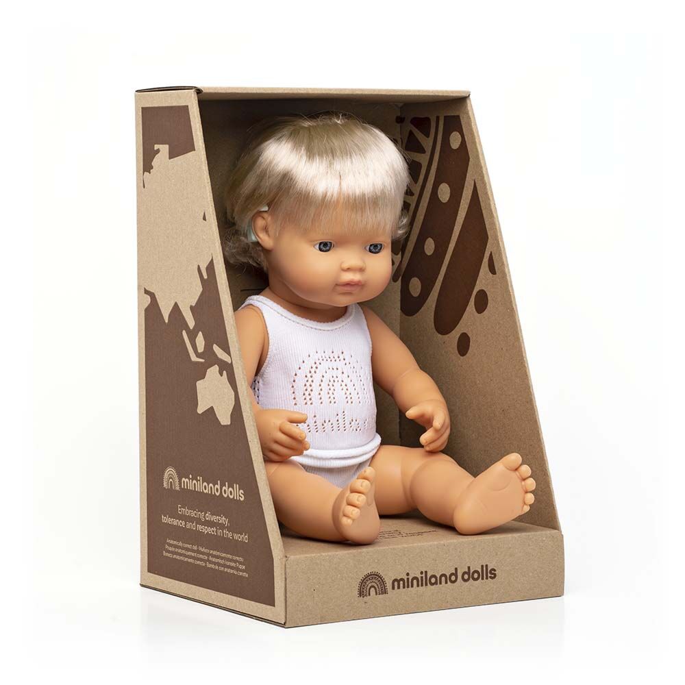 Boneco bebé Miniland Caucasiano de 38cm, com cabelo loiro e aparelho auditivo, dentro da sua caixa de cartão aberta que destaca a mensagem de diversidade.