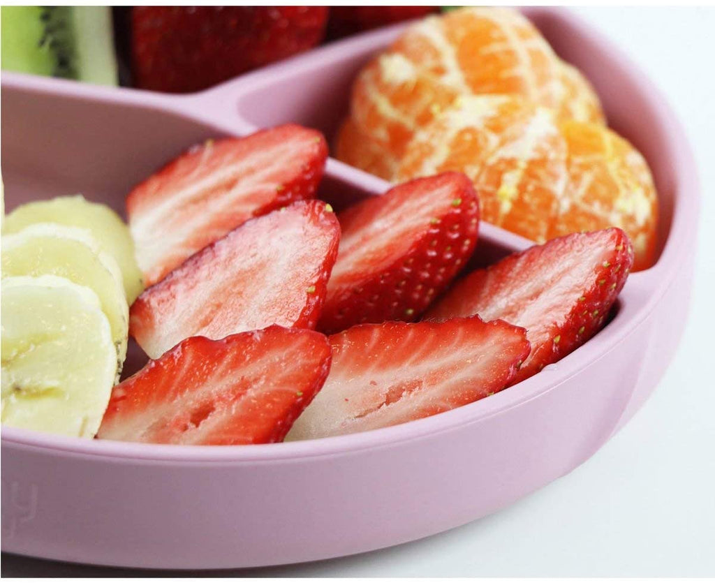 Close-up de um prato de silicone com fatias de morango, gomos de tangerina e banana, mostrando o uso para fruta.