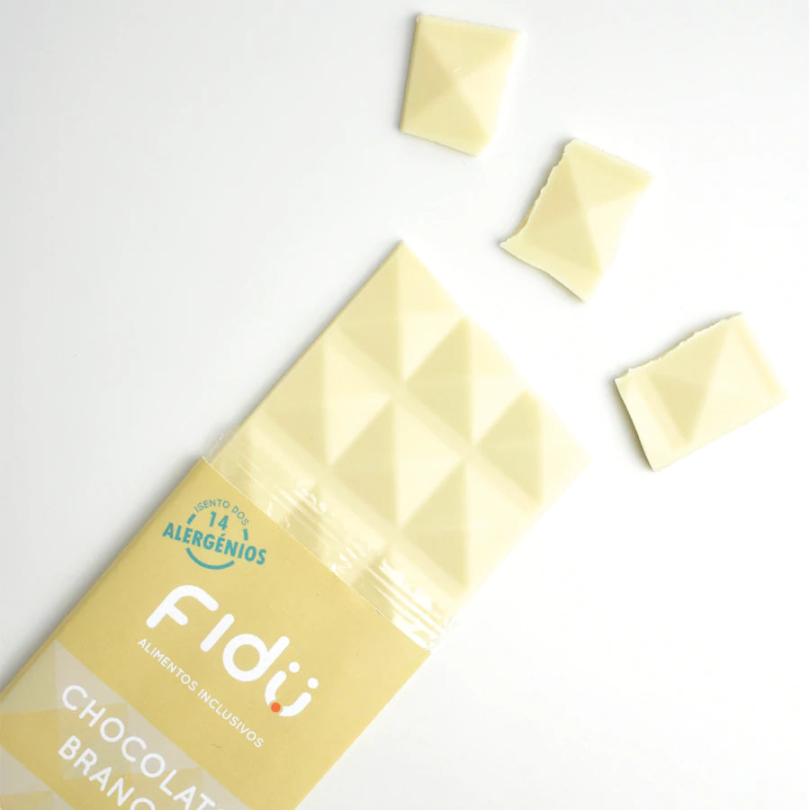 Barra de chocolate branco Fidu com leite de coco parcialmente desembalada, mostrando a textura e alguns pedaços partidos.