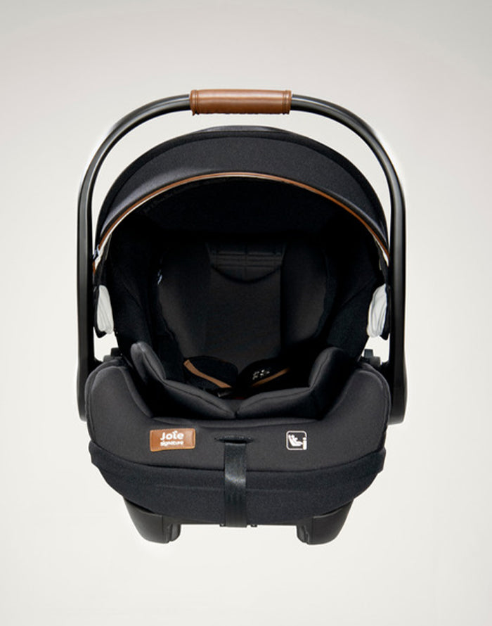 Vista frontal da cadeira auto i-Size, destacando a alça de transporte e a profundidade do assento.