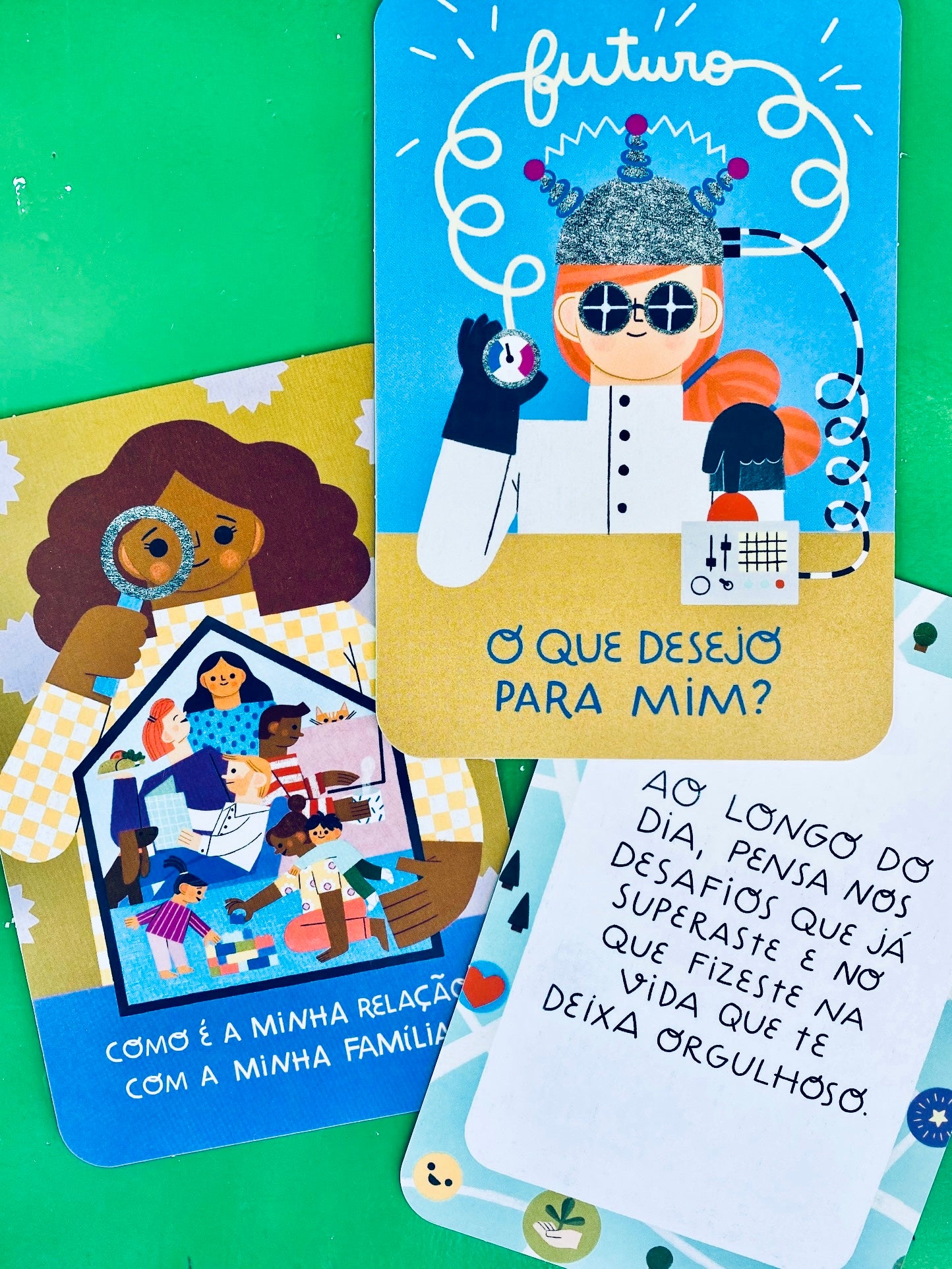 Detalhe de três cartões Quero Conhecer-me! com ilustrações coloridas sobre autoconhecimento, futuro e relações familiares.