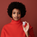 Mulher a segurar o copo menstrual AllMatters OrganiCup Tamanho A translúcido