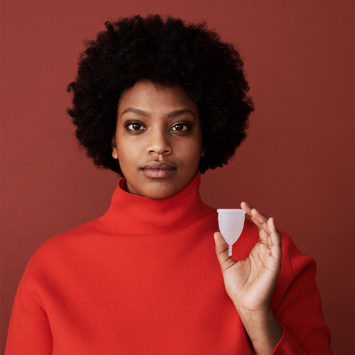 Mulher a segurar o copo menstrual AllMatters OrganiCup Tamanho A translúcido