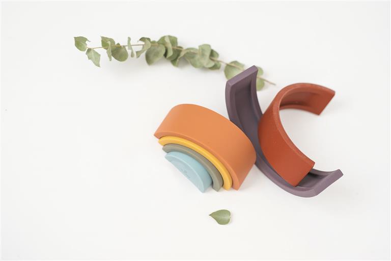 Detalhe das peças do arco-íris de silicone Olmitos, mostrando a textura macia e as cores vibrantes, ideal para o desenvolvimento sensorial do bebé.