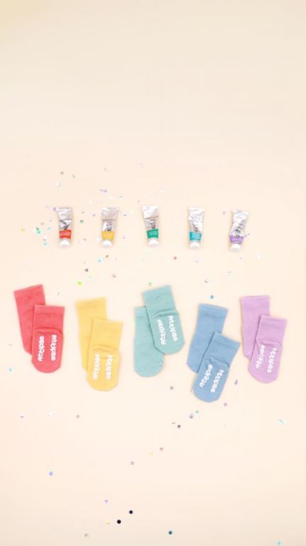 Imagem de uma criança a gatinhar ou a dar os primeiros passos usando as meias Attipas ATTISOCKS, demonstrando a funcionalidade antiderrapante.