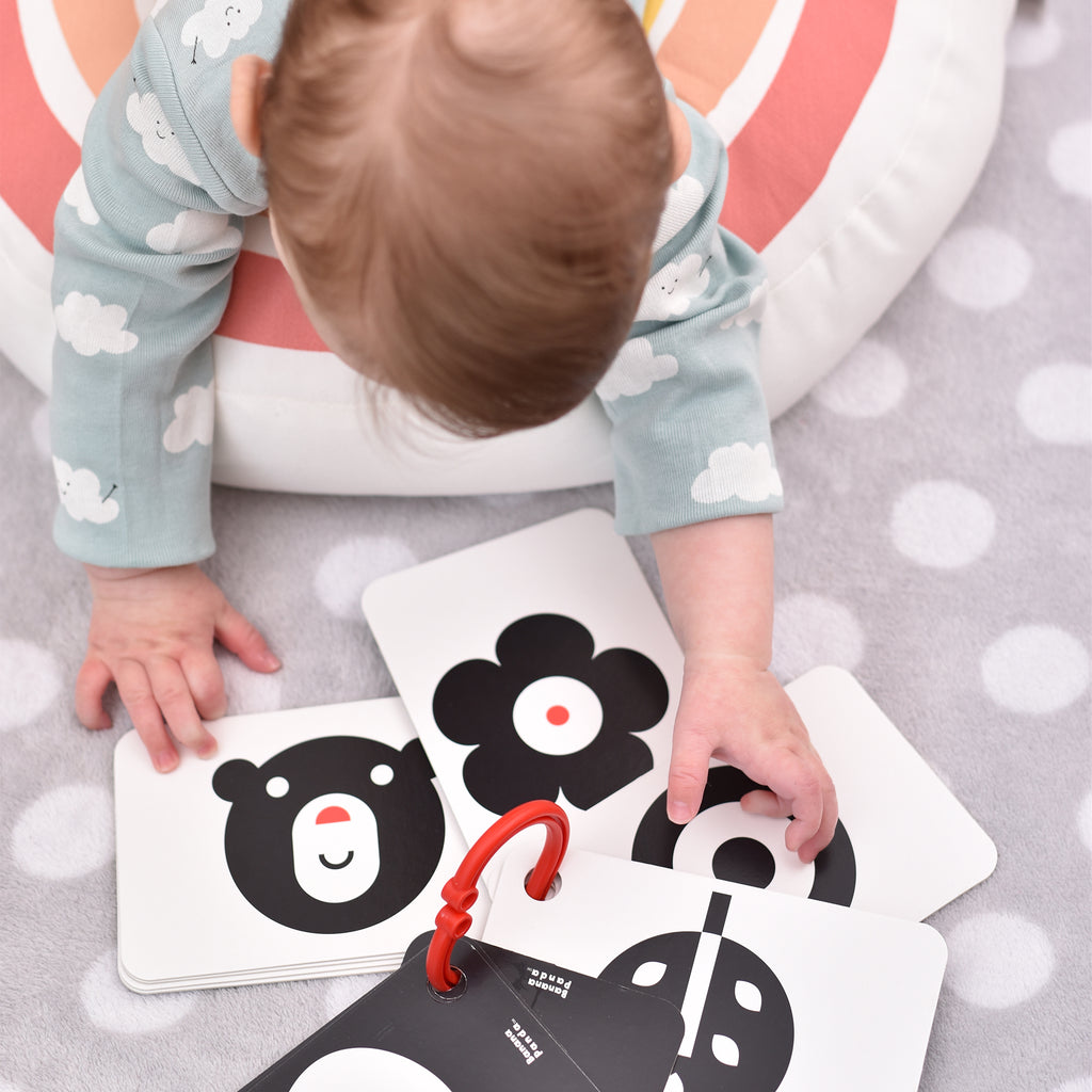 Detalhe dos cartões de alto contraste Banana Panda, mostrando a argola de plástico robusta incluída para pendurar no berço ou carrinho.
