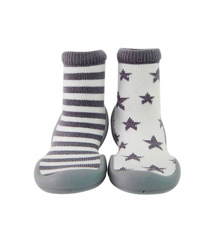 Par de Banannas Baby Shoes modelo estrelas e riscas, em tons de cinza e branco. Um pé apresenta padrão de riscas horizontais, enquanto o outro tem estrelas espalhadas. O design assimétrico e a sola flexível tornam este calçado barefoot ideal para os primeiros passos do bebé.

