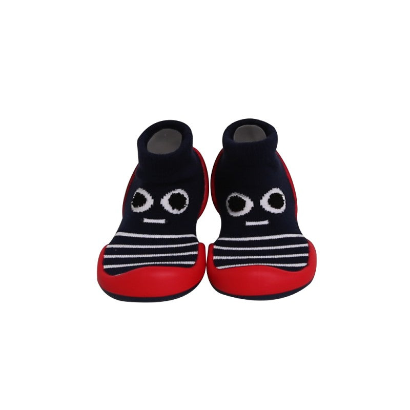 Par de Banannas Baby Shoes no modelo Eyes, em tons de azul-marinho, vermelho e branco. O calçado tem um design divertido com um rosto sorridente na parte superior e padrão de riscas. Possui uma sola flexível e antiderrapante em vermelho, combinada com um forro tipo meia ajustável, proporcionando máximo conforto e liberdade de movimento para os primeiros passos do bebé.

