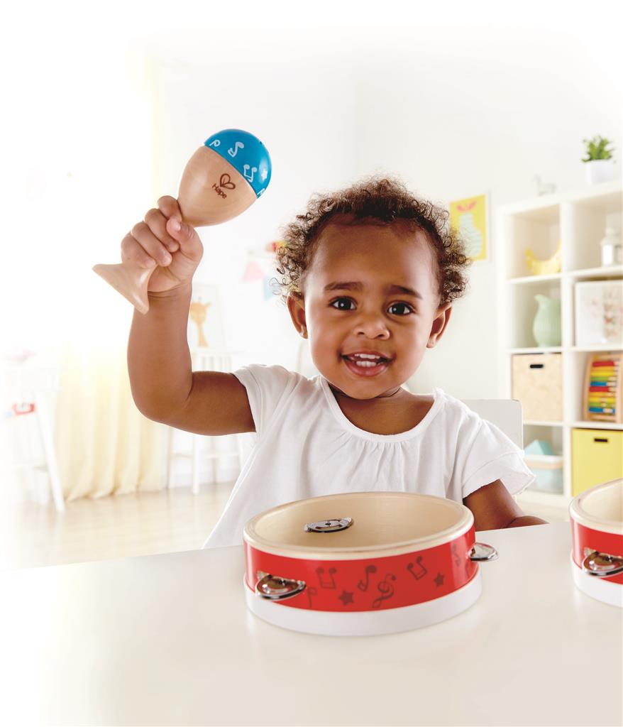 Bebé a segurar uma maraca azul do conjunto de percussão Hape